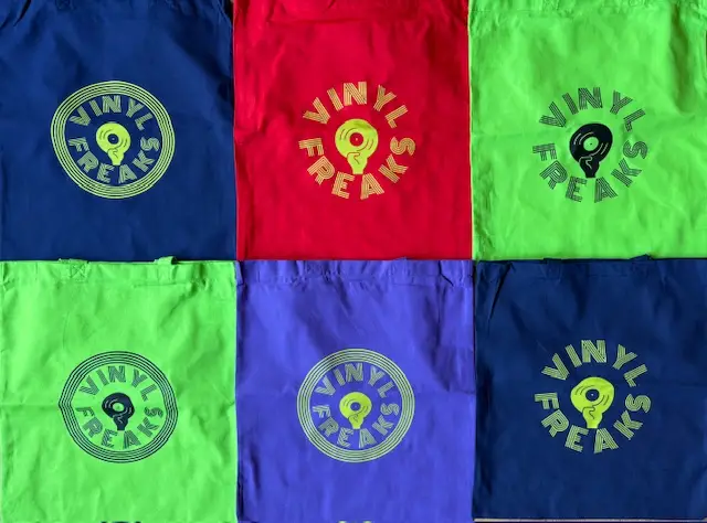 Six colorful bag laid flat in blue, red, lime, purple, and navy, each with a circular Vinyl Freaks logo.
